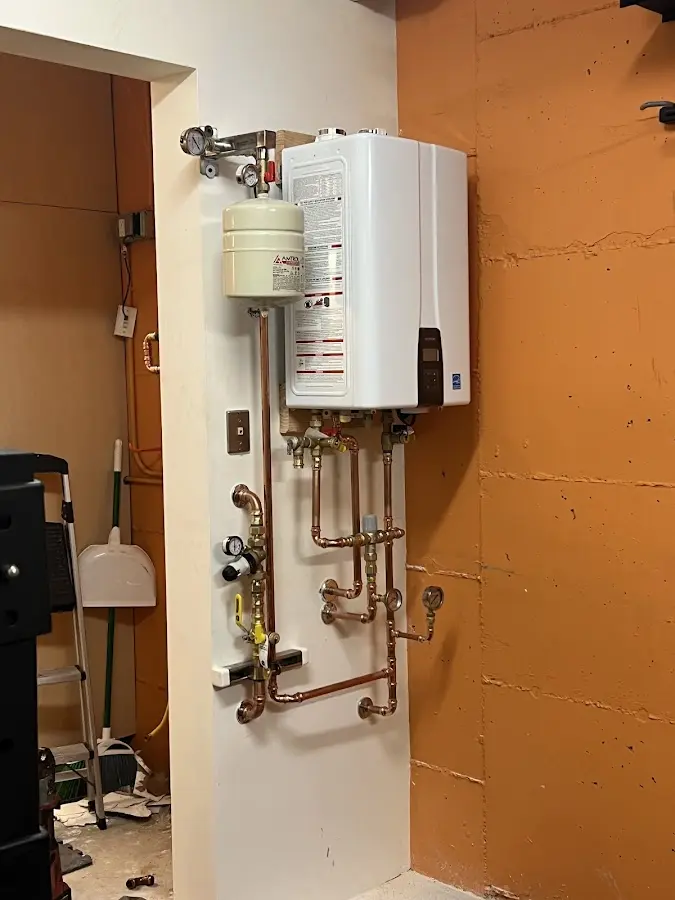 Plumbing technician inspecting water heater connections in Lakeland South